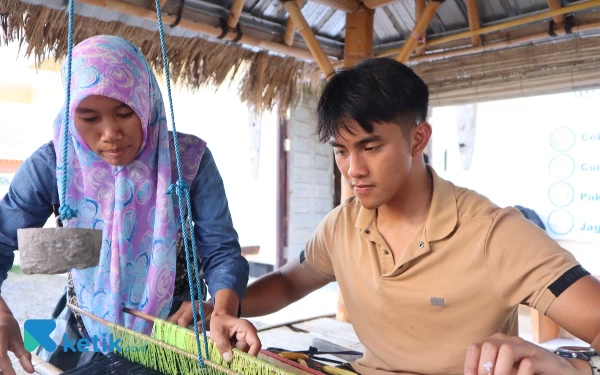 Thumbnail Pembalap Moto3 Mario Aji belajar menenun kain songket Lombok. (Foto: Samsul Hadi Mustofa/Ketik.co.id)