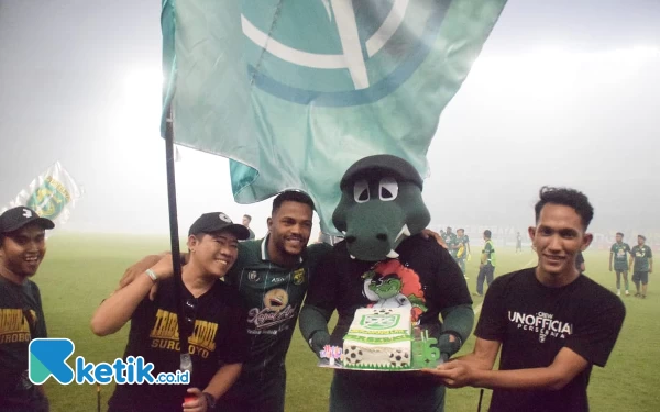 Thumbnail Maskot Persebaya Jojo (dua dari kanan) bersama pemain Persebaya Paulo Victor mendapatkan kue dari Bonek, Minggu (18/6/2023). (Foto : M.Khaesar/Ketik.co.id)