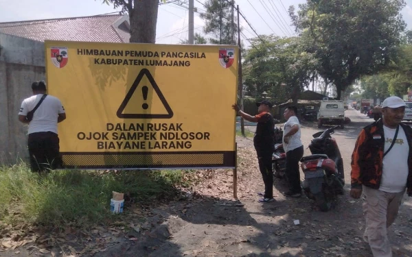 Thumbnail Berita - Jalan menuju Pasirian Rusak dan Rawan Kecelakaan, Pemuda Pancasila Lumajang Pasang Banner Peringatan