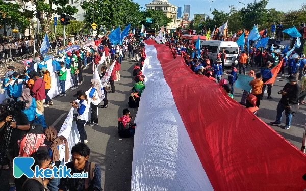 Thumbnail Peserta aksi demo May day tampak membawa bendera merah putih berukuran besar, Rabu (1/5/2024). (Foto: Khaesar/Ketik.co.id)