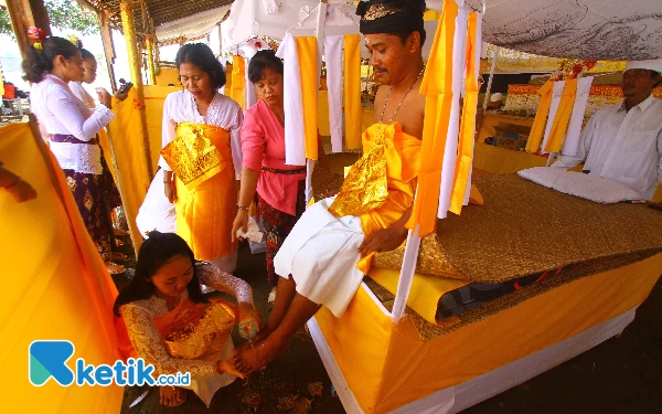 Thumbnail Pihak keluarga membasuh kaki yang mengikuti ritual Metatah atau potong gigi massal di Krematorium Setra Ganda Wangi, Kelurahan Talang Jambe, Kecamatan Sukarami Palembang, Sumatera Selatan, Jumat (7/6/2024). Prosesi potong gigi massal yang diikuti sebanyak 14 orang umat Hindu sebagai simbol untuk membersihkan keangkaramurkaan dan keserakahan dari diri seseorang. Ada 6 buah gigi yang dikikis sebagai simbol sad ripu, yaitu 4 buah gigi seri dan 2 buah gigi taring. (Wahyu Rahmanto/Ketik.co.id)