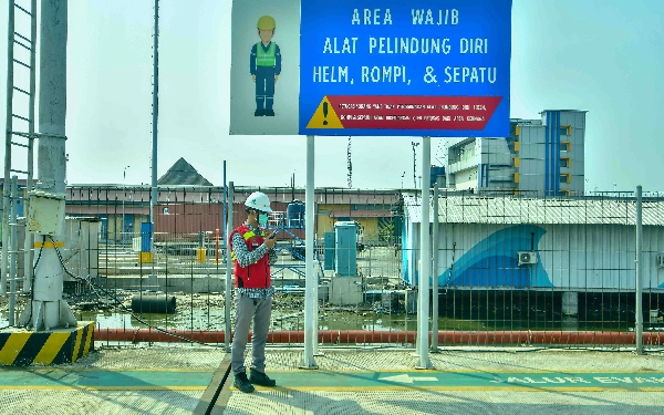 Thumbnail Seorang petugas kemanan dengan APD lengkap sedang berkoordinasi memantau kondisi di Pelabuhan Samudera 2 Subholding PT Pelindo Multi Terminal (SPMT) Branch Tanjung  Emas Semarang, Rabu (22/5/2024). (Foto: Achmad Fazeri/Ketik.co.id)