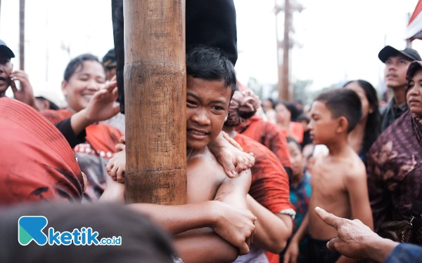 Thumbnail Ekspresi seorang anak yang mengikuti lomba panjat pinang di halaman depan Hotel Wyndham Opi Jakabaring, Palembang, Minggu (18/8/2024). (Foto: Wisnu Akbar Prabowo/Ketik.co.id)